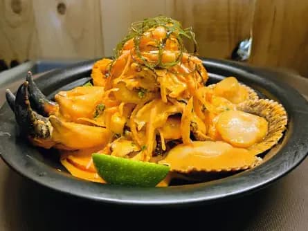 Ceviche en crema de ají amarillo con conchas, pinzas de cangrejo y limón